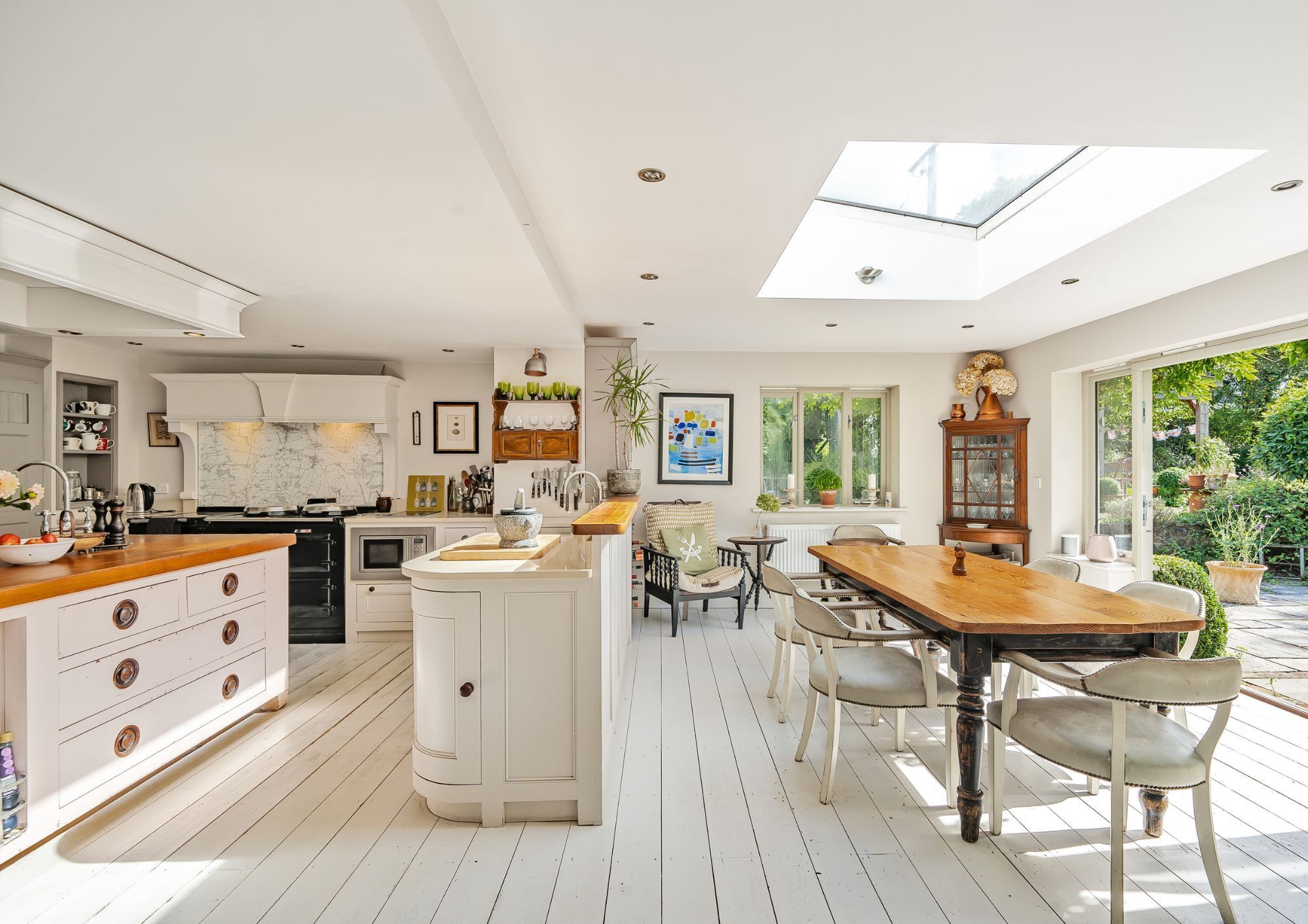 A large, light and modern kitchen/diner with a velux window and bi-fold doors opening to the garden.