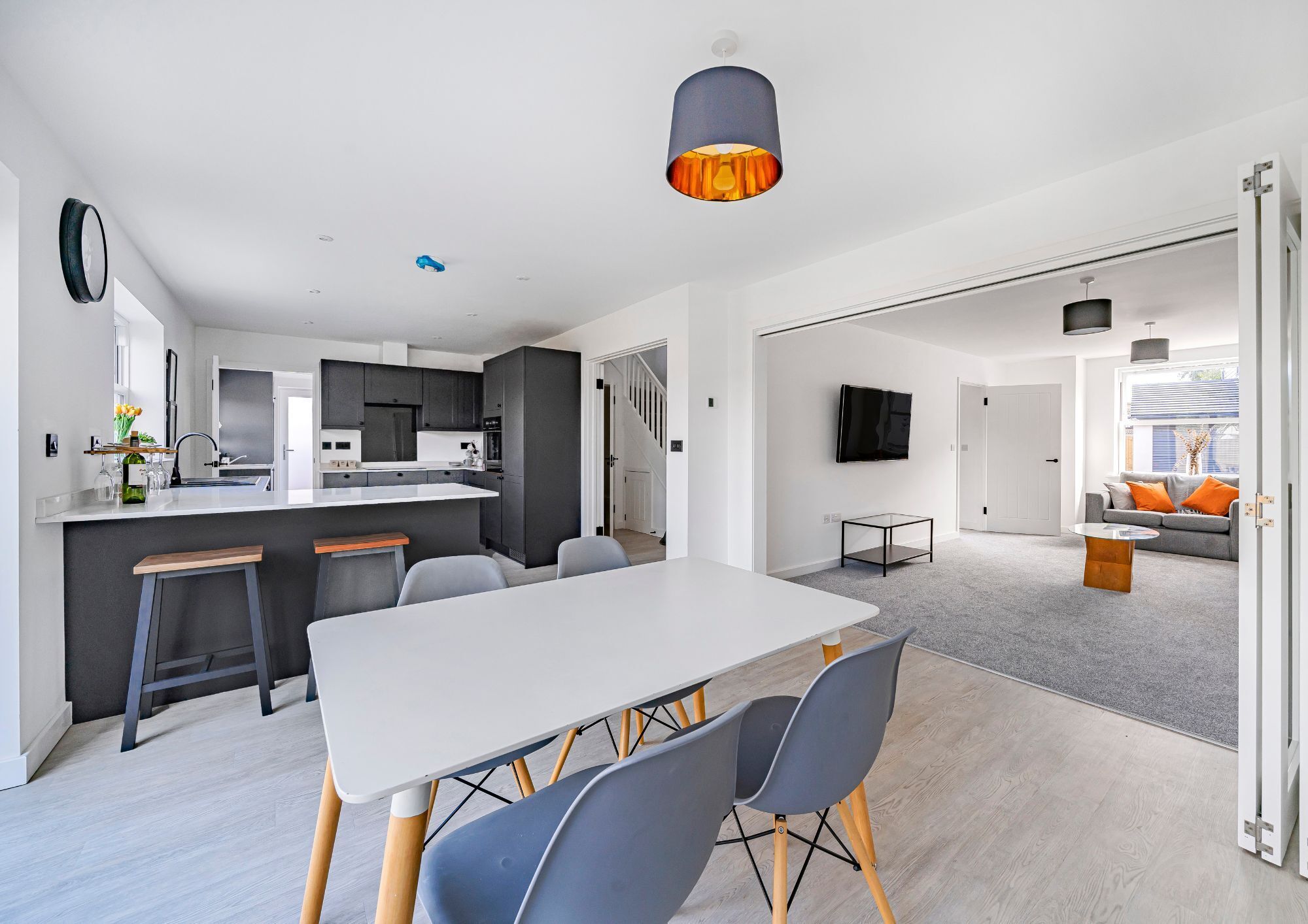 Open plan kitchen/diner in a new build house with bi-fold doors opening up to a lounge.