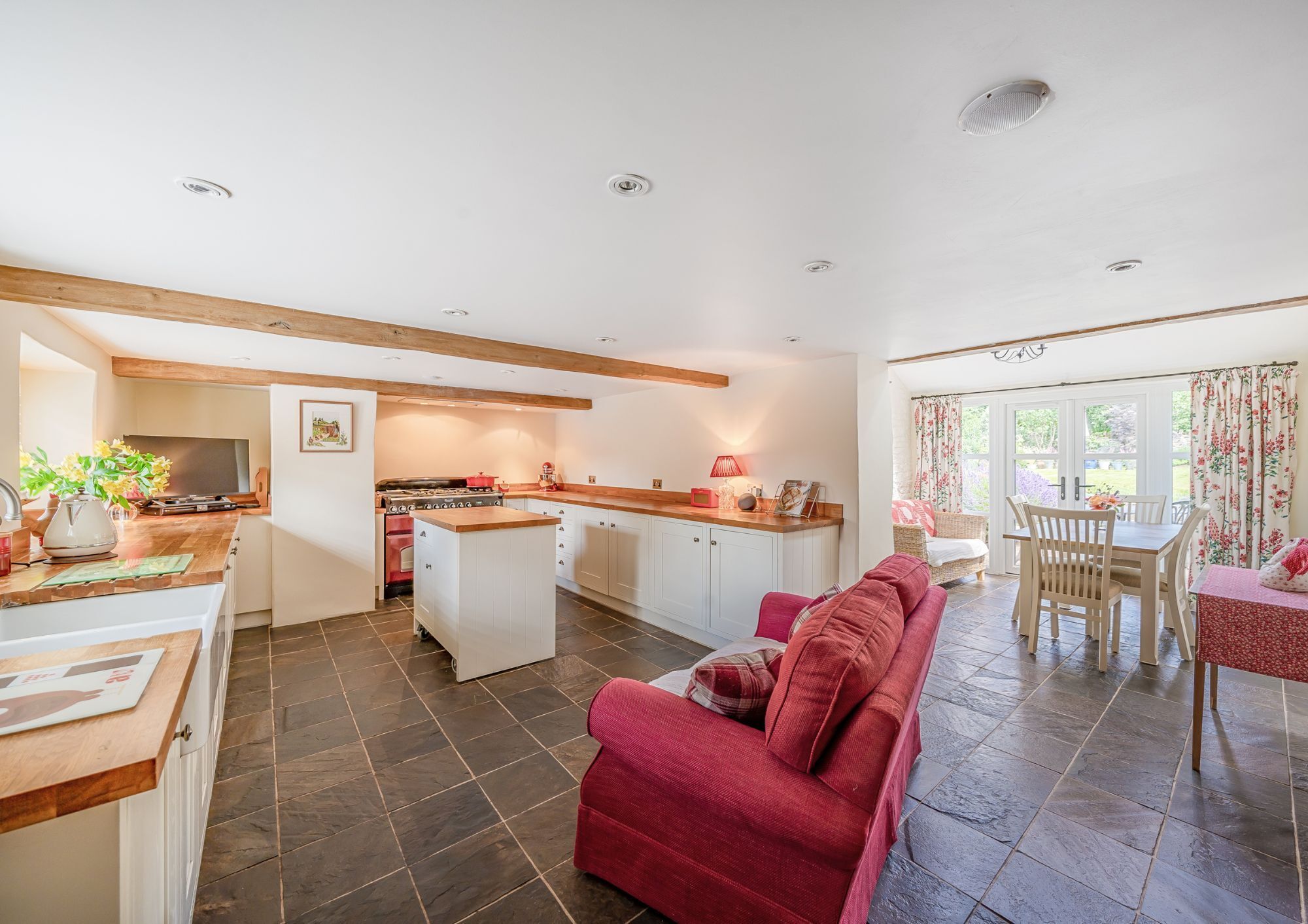 A bright and neutral open plan kitchen/diner with a slate floor throughout. 