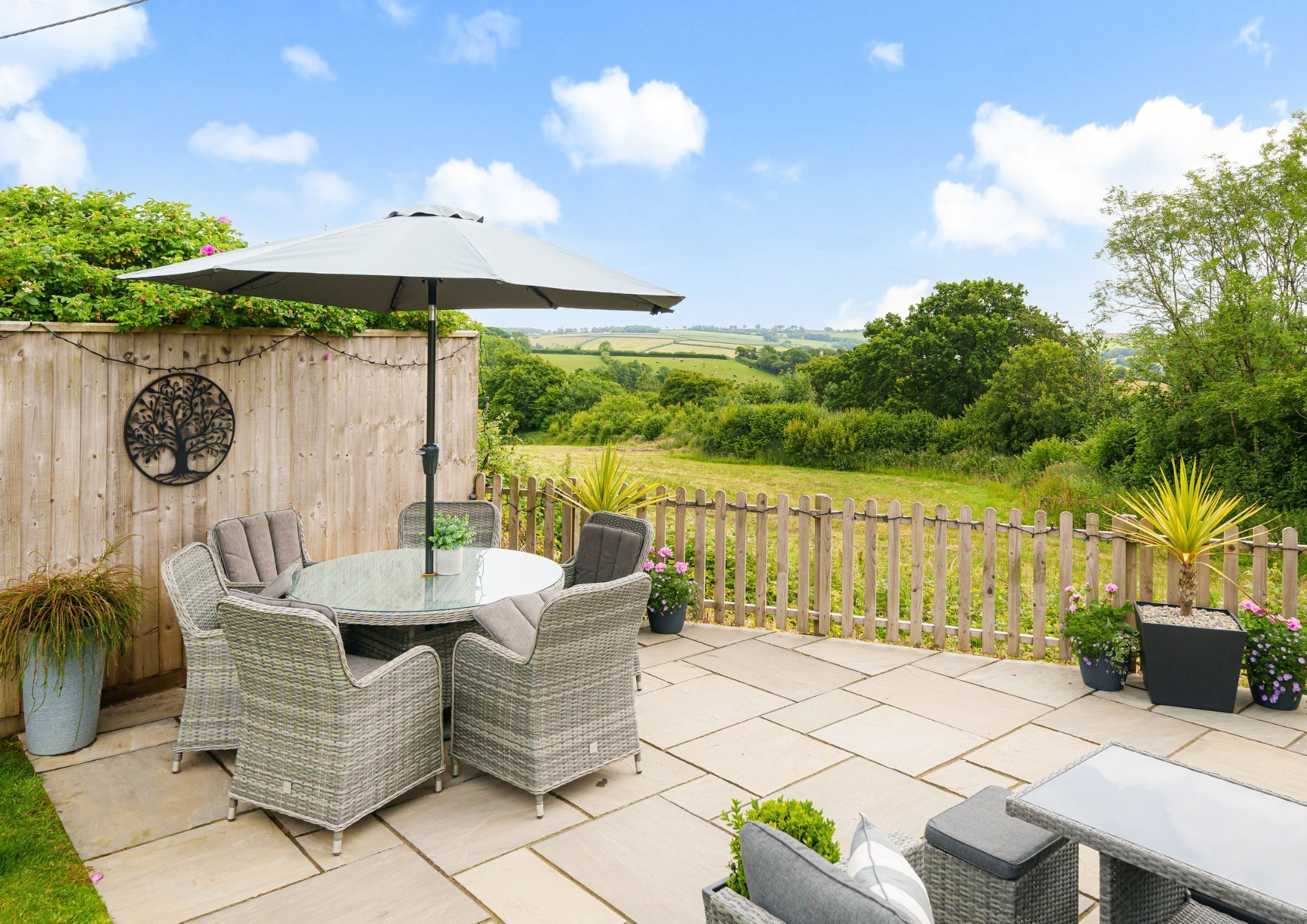 Patio in the rear garden with furniture and views over surrounding countryside.