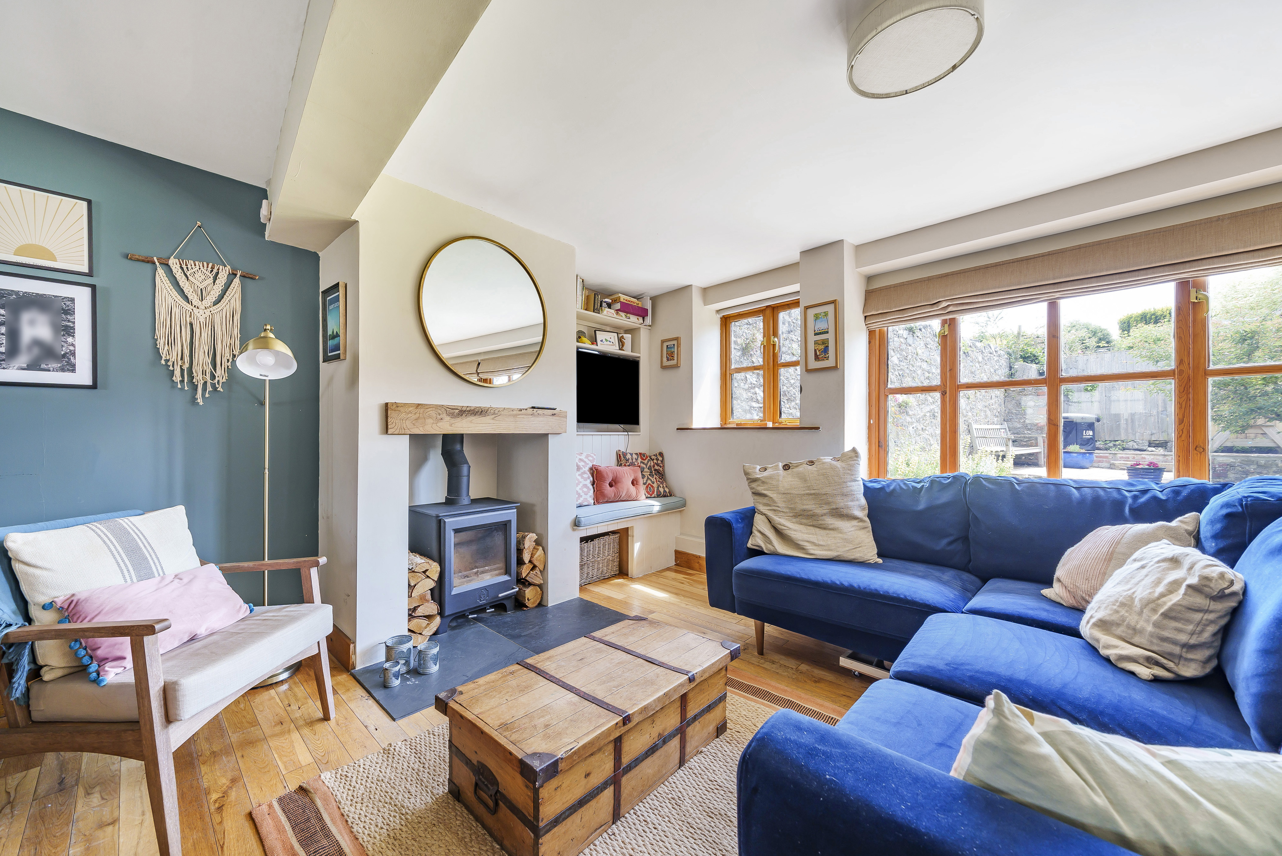 A sitting room in a barn conversion with sofas surrounding a central wood burner.