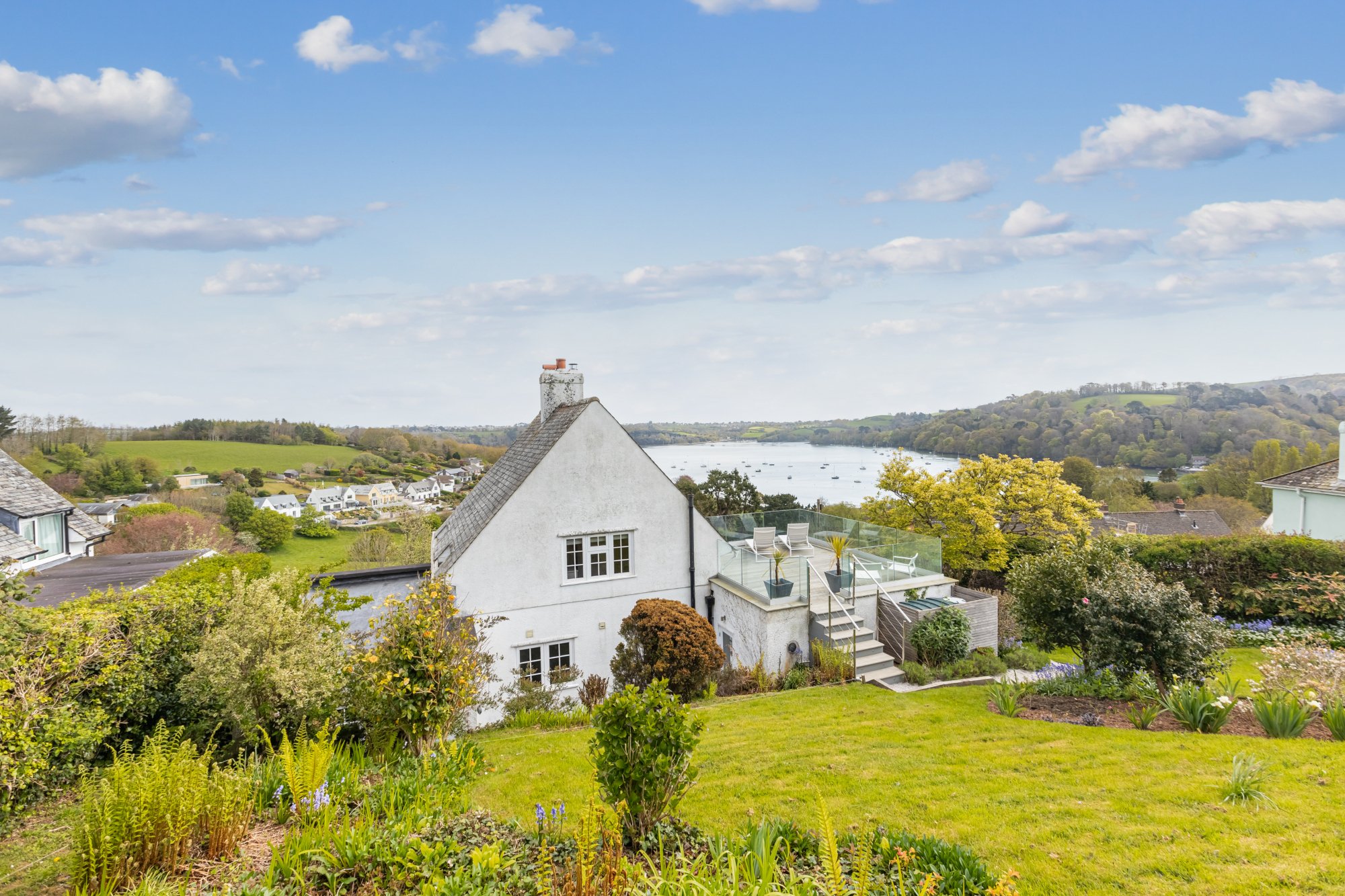 Image of white house in dittisham, overlooking river, surrounded with green garden