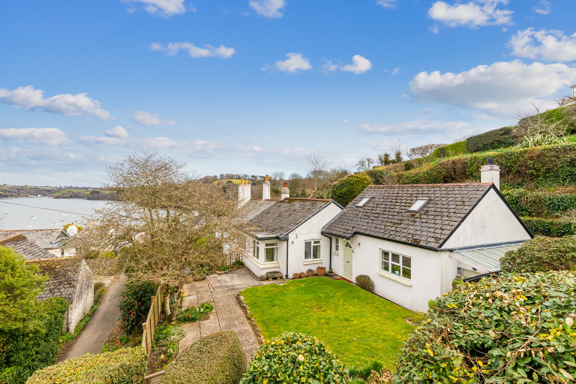 white cottage in dittisham, overlooking river, with green garden