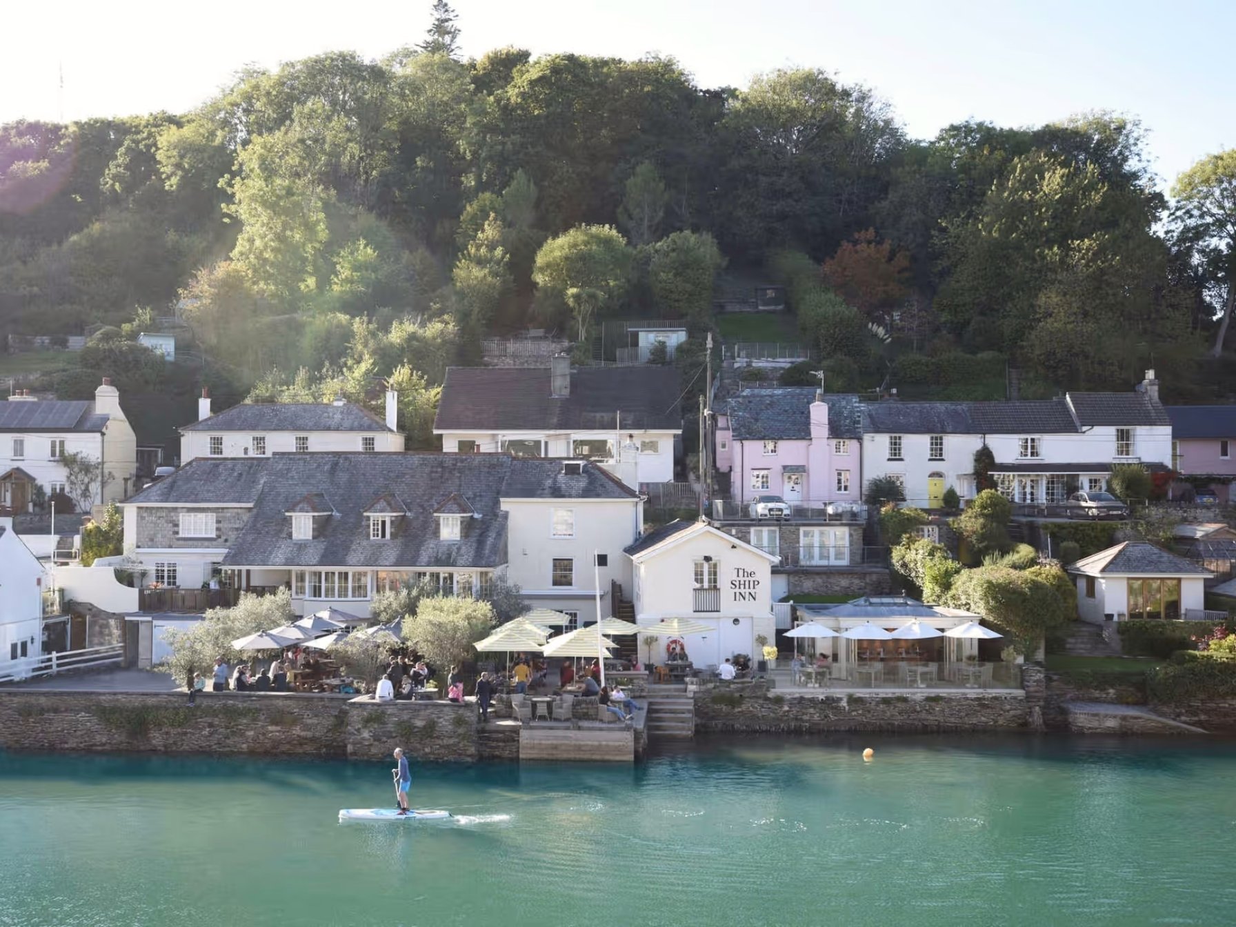 Noss Mayo, The Ship Inn pub, waterside view with paddleboarder