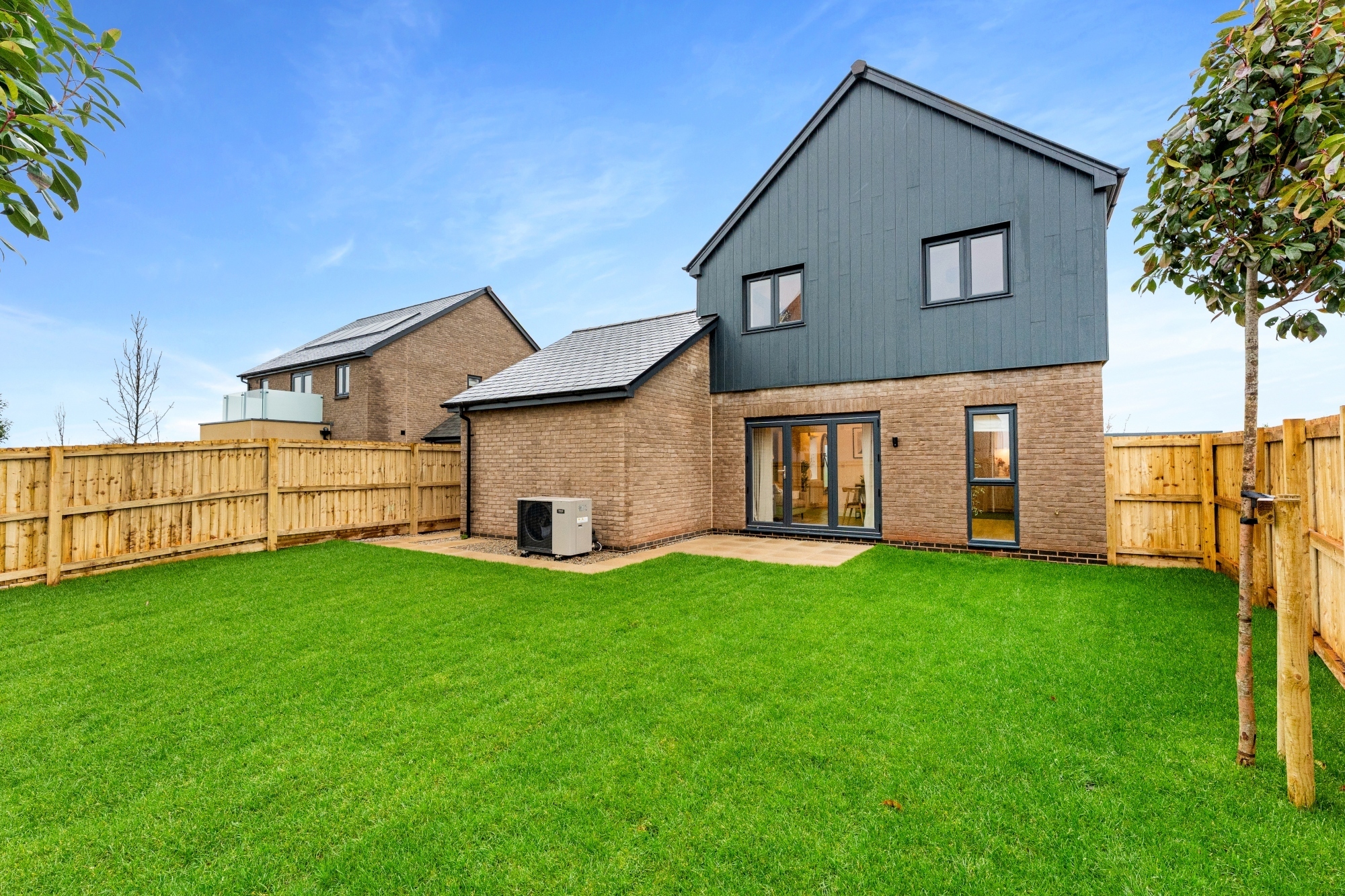 new build home back garden with solar panels and an air source heat pump