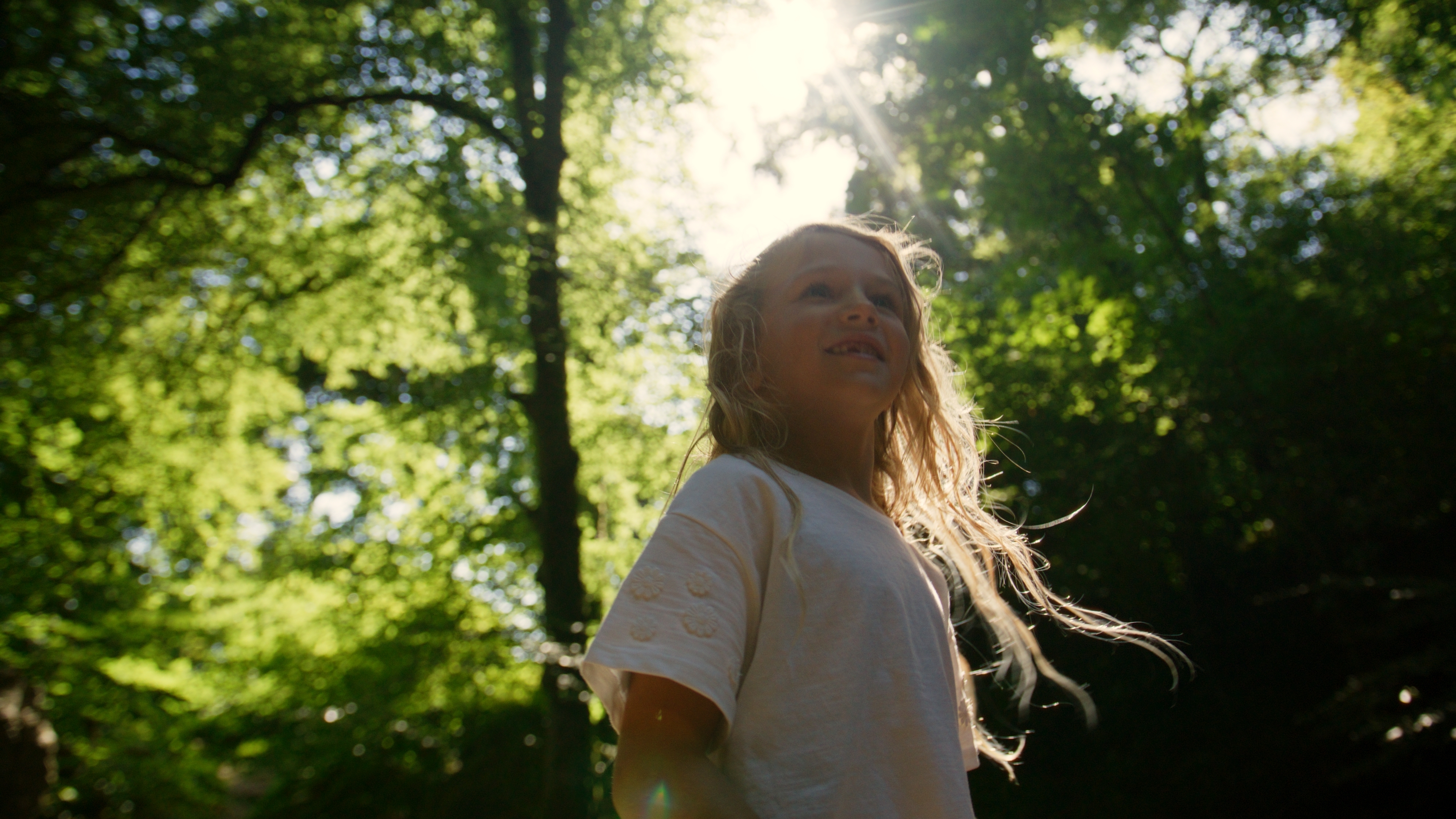 girl in woodland, surrounded by trees and greenery