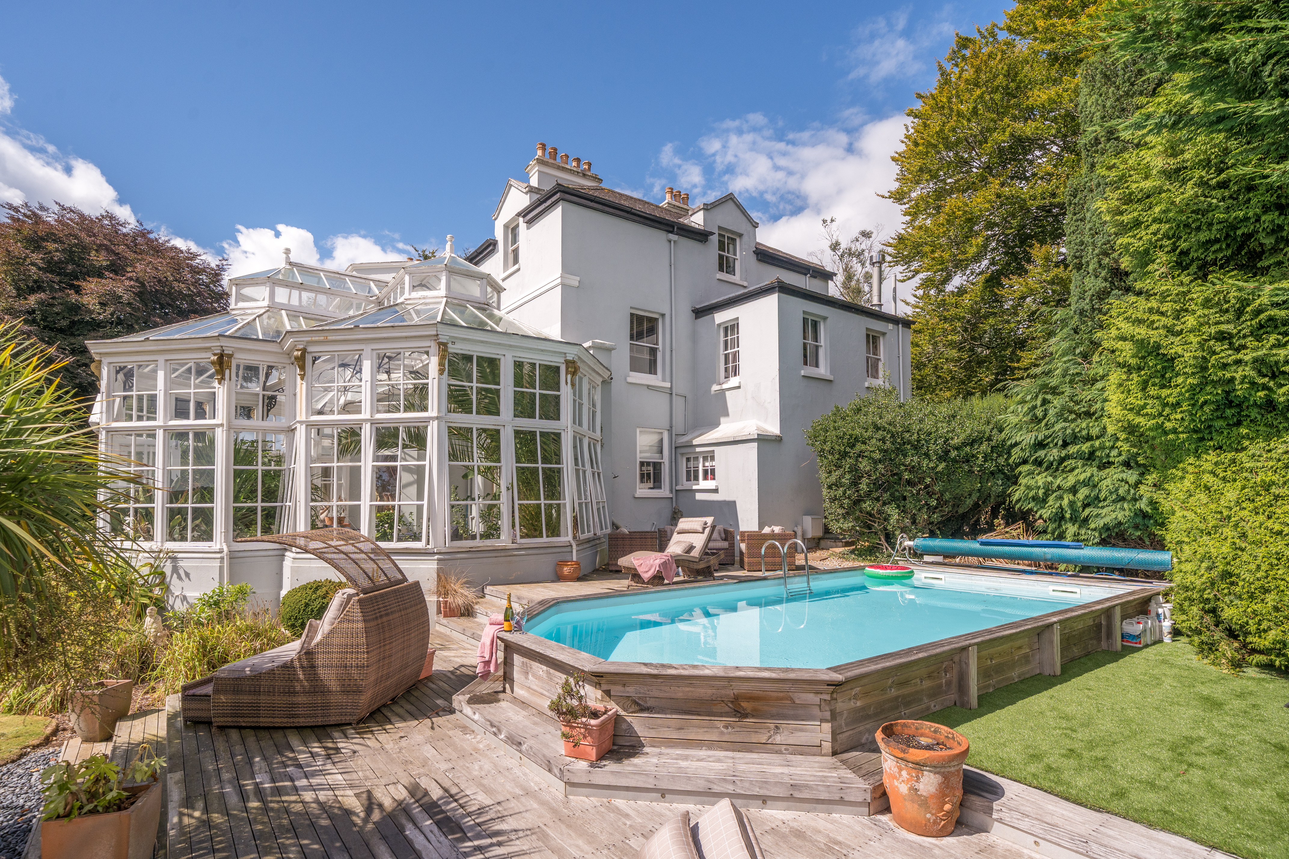 photo of grand house with orangery and outdoor swimming pool