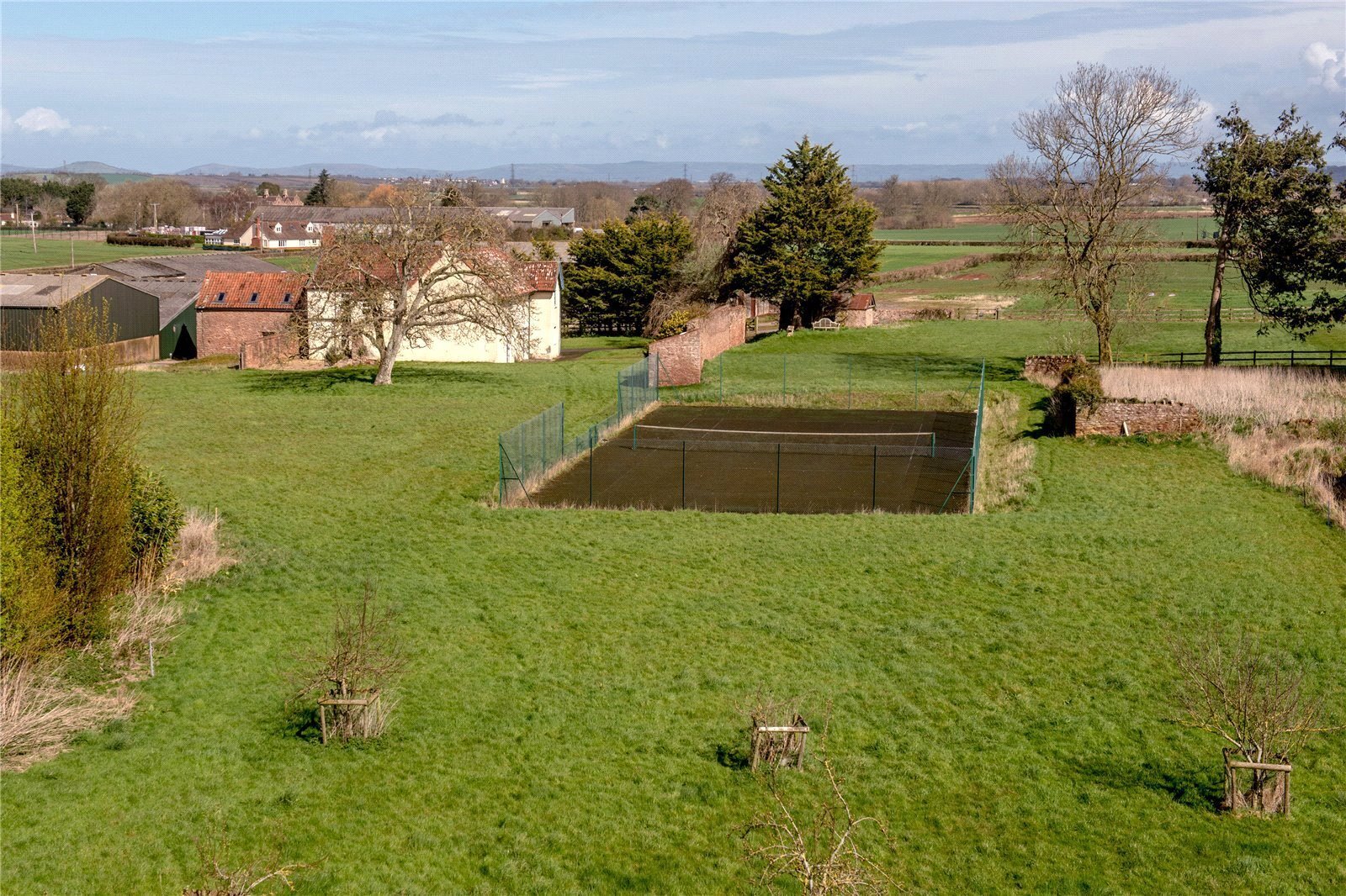 tennis court in the grounds of a rural property