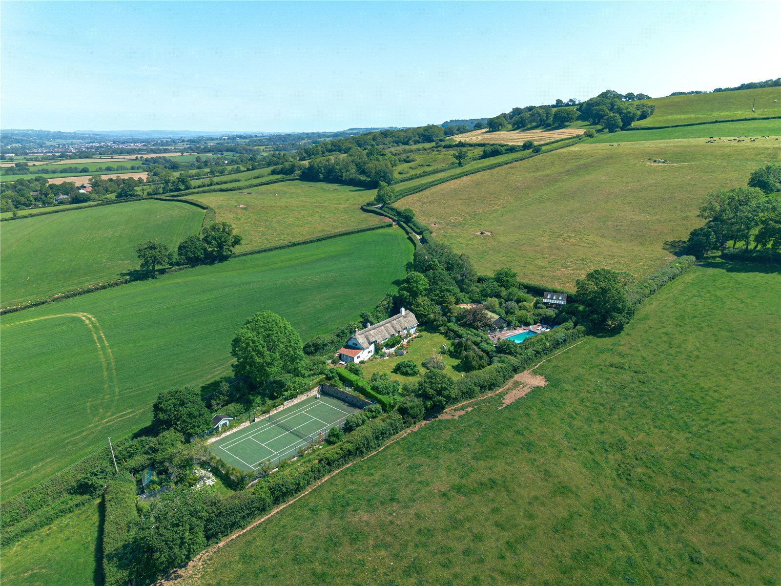 aerial view of rural property with tennis court in the grounds